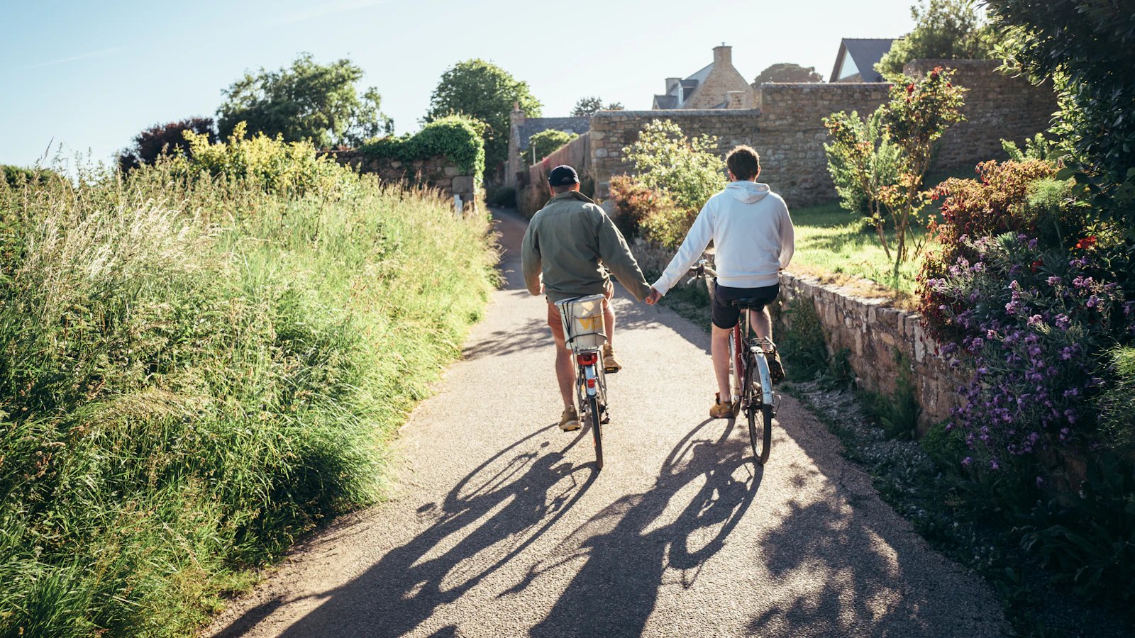 Echtpaar fietst hand in hand op een zonnige dag.