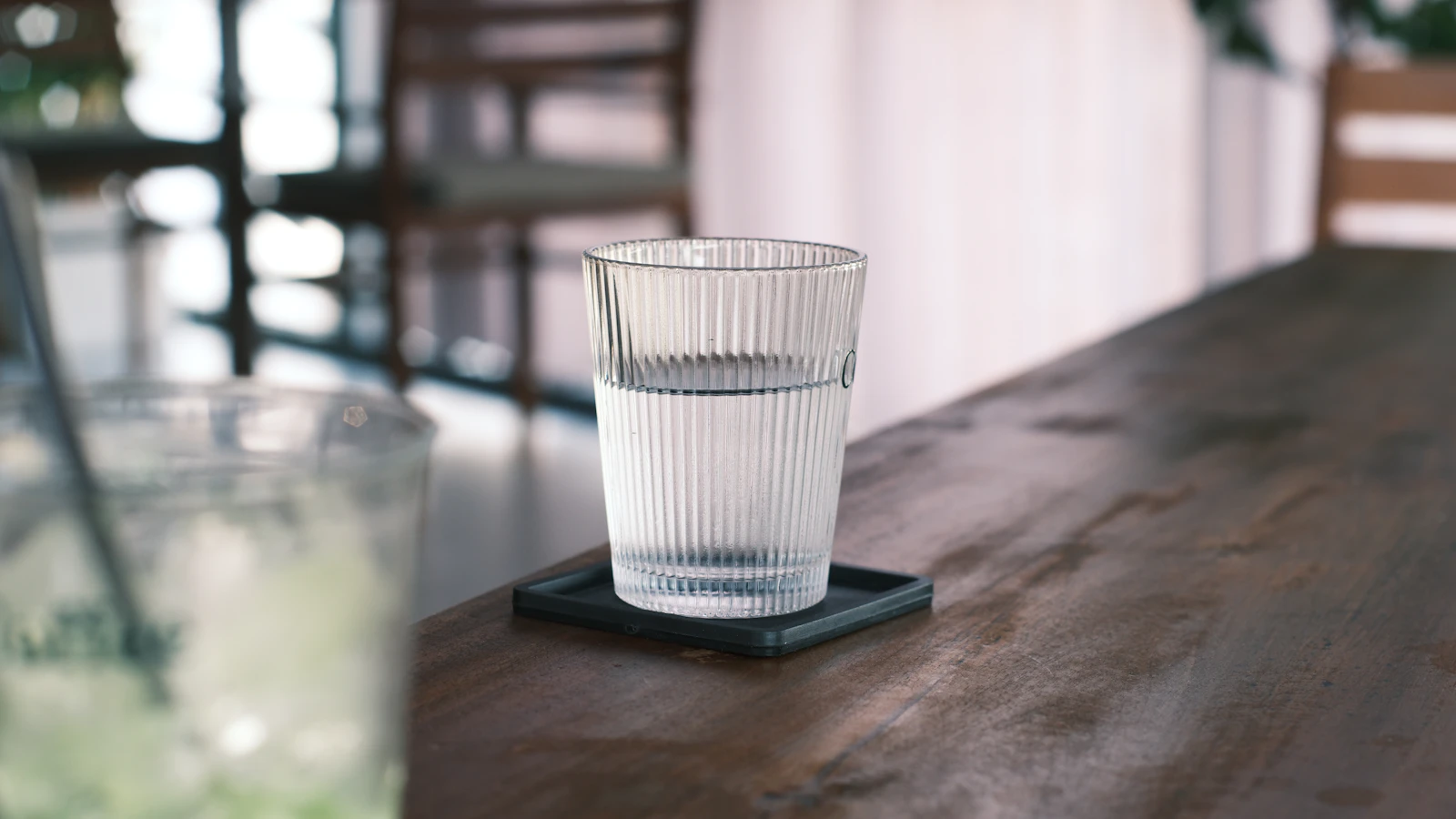 Een helder glas water op een houten tafel.
