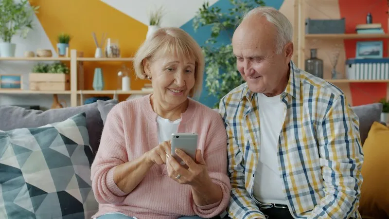 Een ouder echtpaar kijkt samen op een telefoon